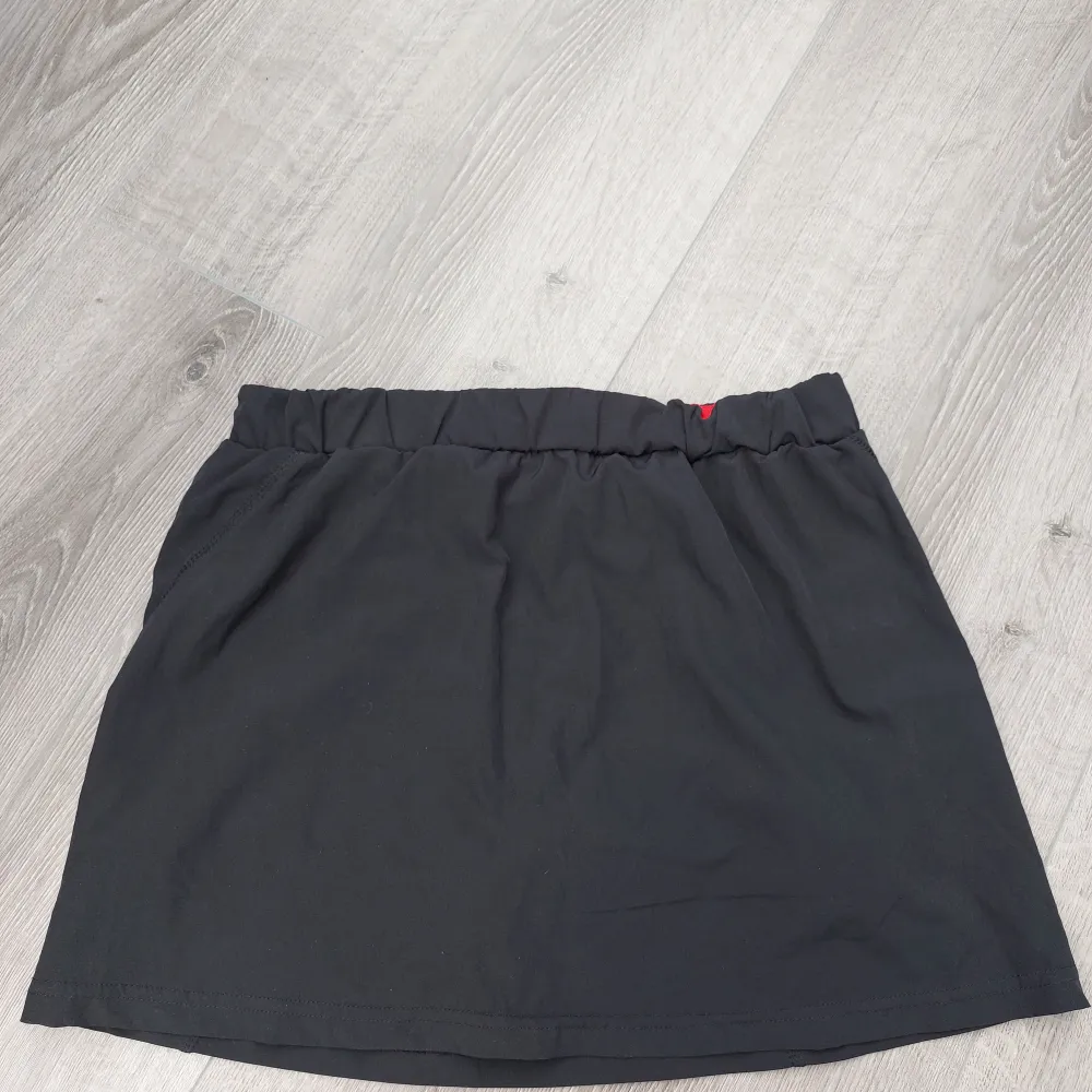 Söt, svart kjol som är bra för vandring. Den har inbyggda shorts och är i midilängd. 🖤. Sportswear.