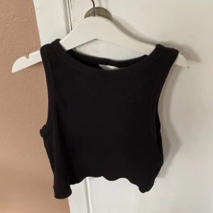 Svart croppad linnetopp från H&M - Säljer en svart croppad linnetopp från H&M. Toppen är ärmlös och har en tight passform, perfekt för sommaren eller en festkväll. Materialet är mjukt och stretchigt, vilket gör den bekväm att bära. Köp direkt eller ge prisförslag 💛köparen betalar för frakt!