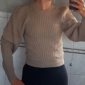 Beige stickad tröja - Säljer en superfin beige stickad tröja. Den är ribbad och har långa ärmar. Perfekt för höst och vinter! Tröjan är i fint skick och passar till både vardag och fest. Den är normal i passformen och väldigt bekväm att ha på sig. Köp den nu och håll dig varm och snygg! 💛