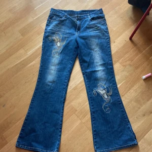 Bootcut jeans med fjärilsmotiv  - Bootcut/flare jeans med fjärilsmotiv och gemstones. Inte säker på märket då jag köpte secondhand och lappen är svår att tyda. Bra skick och pris kan diskuteras 