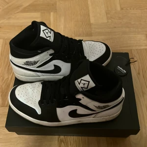 Jordan 1 mid Diamond Shorts - Säljer ett par svartvita Nike Air Jordans i storlek 43. Skorna är i bra skick med några tecken på användning. De har en klassisk design med svart och vit färg, snörning och den ikoniska Air Jordan-loggan på sidan. Perfekta för både vardag och fest! Priset kan diskuteras. Köptes för 3900kr och har kvittot. KÖPT FRÅN RESTOCKS