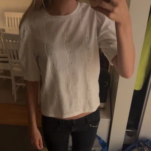 Vit blus från Pieces - Säljer en superfin vit blus från Pieces i storlek XS. Blusen har ett vågigt mönster och är gjord i ett lätt och luftigt material, perfekt för vår och sommar. Den har korta ärmar och en rund halsringning. Passar både till vardags och fest!