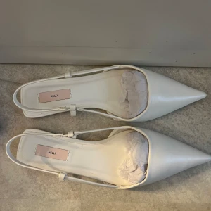 Vita snygga slingbacks  - Köpt från Nelly för 349 kr. Aldrig använd . Storlek 39. Skulle säga att dem är normal i storleken. Så snygga och fräscha. Använd gärna köp nu <3 