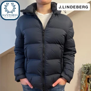 J.Lindberg Puffer Jacka | Marinblå  - Otroligt snygg och varm vinterjacka från J.Lindberg! Skicket är i 8/10 (en lagning utförd av skräddare finns på framsidan men syns ej vid användning) Storlek: M. Han på bilden är 176cm och 70kg. Skriv vid frågor🙌