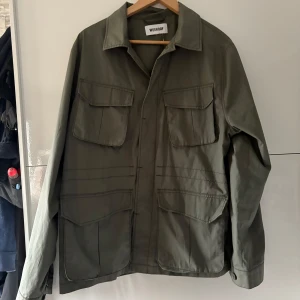 Grön overshirt från Weekday - Snygg grön overshirt från Weekday med fyra stora fickor framtill. Perfekt för lager-på-lager-stil. Den har en klassisk krage och långa ärmar.