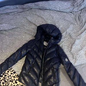 Moncler jacka  - Snygg svart dunjacka från Moncler,använd knappt en säsong o inga defekter på. Storlek 14yo men passar även som Xs/Xss. Jag är själv runt 162 o den passar bra o man får under en hoodie. Är marin blå men ser ut o vara svart. Pris kan diskuteras o köparen står för frakten.