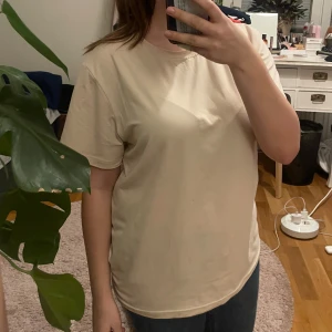 Beige t-shirt från SHEIN - Säljer en enkel och stilren beige t-shirt från SHEIN. T-shirten har en normal passform och korta ärmar, perfekt för en avslappnad look. Tillverkad i ett mjukt material som känns skönt mot huden.