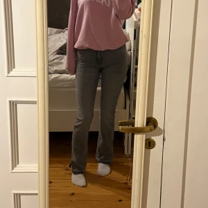 Grå bootcut jeans med slits  - Snygga grå bootcut jeans med medelhög midja och slits nere vid fötterna. De är även sprättade längst ner. Jag är 1,75cm lång. Aldrig använda bara sprättade. 