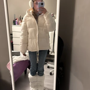 Baggy creme puffer jacka - Man kan justera den nertill för att göra den lite tajtare. Den är lite smutsig men kan göra rent den. De har två fickor egentligen men ens göms i bilden