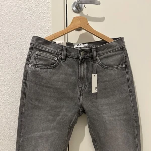 Grå jeans från Lager157 - Spillransny grå jeans från 157 i modellen New Classic. De har en midwaist passform och är i standard fit. Perfekta för en stilren look.