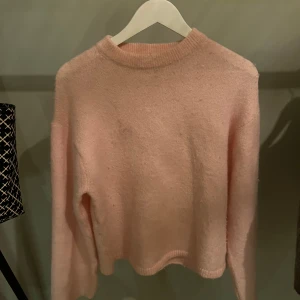 Rosa stickad tröja från Gina Tricot - Mysig rosa stickad tröja från Gina Tricot i storlek XS. Perfekt för kyliga dagar med sin mjuka och varma känsla. Tröjan har långa ärmar och en klassisk rund halsringning.
