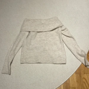 Beige offshoulder tröja från Gina Tricot - Säljer en trendig stilren beige offshoulder tröja från Gina Tricot. Tröjan har långa ärmar och en bred krage som ger en avslappnad look. Perfekt för en trendig och bekväm stil. Helt ny aldrig andvänt, säljs ej mer på Gina tricot. Hör gärna av er vid frågor❤️😍🙌🏻🎄