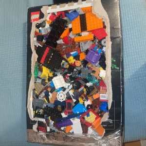 Blandade LEGO-bitar i kartong - En stor samling av blandade LEGO-bitar i olika färger och former, förpackade i en kartong. Perfekt för kreativa byggprojekt och att skapa egna unika konstruktioner. Innehåller både små och stora bitar samt specialdelar. Den är jättebra bara mina barn har tröttnat på de. 