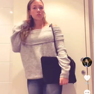 Grå offshoulder tröja - Säljer en mysig grå offshoulder tröja med ribbad struktur. Perfekt för en avslappnad stil med långa ärmar och en bred krage som kan bäras nedanför axlarna. Passar bra till jeans eller kjol för en chic look.