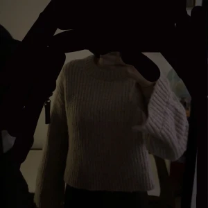 Beige sticke tröja  - Självklart! Här är den uppdaterade texten:  Jag säljer en  Beige stickad tröja från Gina Tricot. Den har en lite öppen design vid armarna och vid midjan, vilket ger den en unik stil. Tröjan är jättevacker . Se gärna bilden för att få en bättre uppfattning!