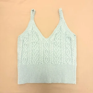 Ljusblå stickad linnetopp - Snygg ljusblå stickad linnetopp med flätmönster och ribbad nederkant. Perfekt för en stilren och bekväm look.