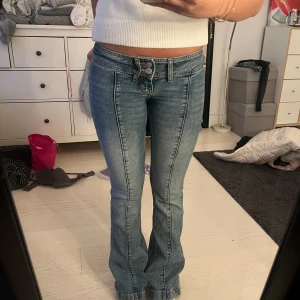 Blå bootcut jeans med knyt - Snygga blå bootcut jeans. De har en lågmidjad passform och en cool detalj med knytband framtill. 