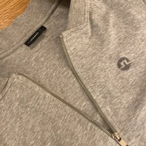 J.lindeberg Full zip - Säljer denna feta gråa J.lindeberg koftan i storlek S! Inga defekter, bra skick. Tröjan är i storlek L men passar liten M/S. Pris 299 eller kom med bud! BVSA