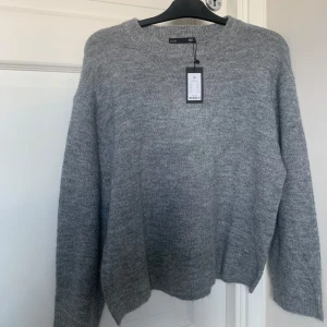 Grå stickad tröja från 157 - Säljer denna helt nya stickade tröjan från lager157 då färgen inte riktigt är min stil 🤍 det är den populära modellen ”cathrine” som är slutsåld i de flesta butikerna! Den är superskön, har bredare armar, oversized o gosig! Nypris är 150 kr ☺️