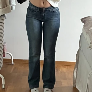 Blå low waist, bootcut jeans från Tommy Hilfiger - Säljer ett par snygga blå jeans från Tommy Hilfiger. De har en klassisk femficksdesign och är i bootcut-stil. Perfekta för både vardag och fest! Innerbenslängd - 72, midjemått 33. Jag på bilden är 160 som referens!💖
