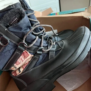 Svarta vinterkängor med snörning - Säljer ett par robusta svarta vinterkängor i storlek 43. De har en slitstark design med snörning och är perfekta för kalla vinterdagar. Perfekta för att hålla fötterna varma och torra under vintern. Det har kostat 1699 kr