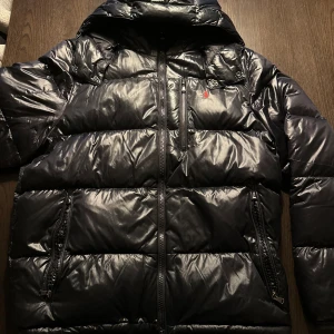 Svart pufferjacka från Polo Ralph Lauren - Säljer en snygg svart pufferjacka från Polo Ralph Lauren i storlek XL. Tycker mer det är strl L än XL. Hör av er vid frågor😁