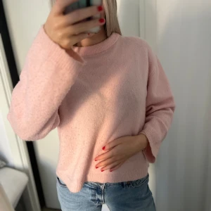 Rosa stickad tröja - Mysig rosa stickad tröja perfekt för kyliga dagar. Den har en enkel design med långa ärmar och en bekväm passform. Perfekt att matcha med jeans för en avslappnad look. Storlek s. Har en noppermaskin som jag kan köra på tröjan innan jag postar!