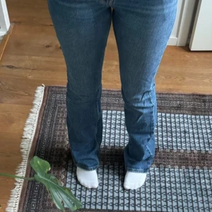 Blå bootcut jeans - Säljer ett par klassiska blå bootcut jeans i bra skick. De har en snygg passform som sitter tight upptill och blir vidare nedtill. Perfekta för både vardag och fest! 🕺