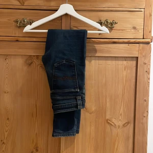 Mörkblå jeans - Säljer ett par snygga mörkblå jeans i bra skick. De har en klassisk femficksdesign och är perfekta för både vardag och fest. Jeansen har en slim passform och är tillverkade i ett slitstarkt denimtyg. Perfekta för höst och vår, ny pris 1399kr! Storlek 27/30