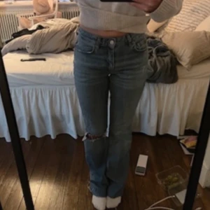 Blå jeans med slitningar - Säljer ett par snygga blå jeans i bra skick. Från ginatricot i storlek 36! De är lätt utsvängda och har en slitning på ena knät. Midwaist. Perfekta för höst och vår!