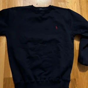 Mörkblå tröja från Ralph Lauren - Säljer en stilren mörkblå tröja från Ralph Lauren. Superbekväm och i bra skick! Skriv för fler bilder eller frågor :) Storlek M/L