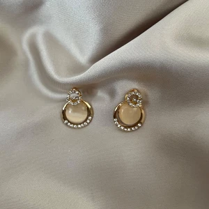 örhängen - Snygga guldörhängen med en rund design Perfekta för att ge en touch av elegans till vilken outfit som helst. De är både stilrena och iögonfallande, vilket gör dem idealiska för festliga tillfällen.