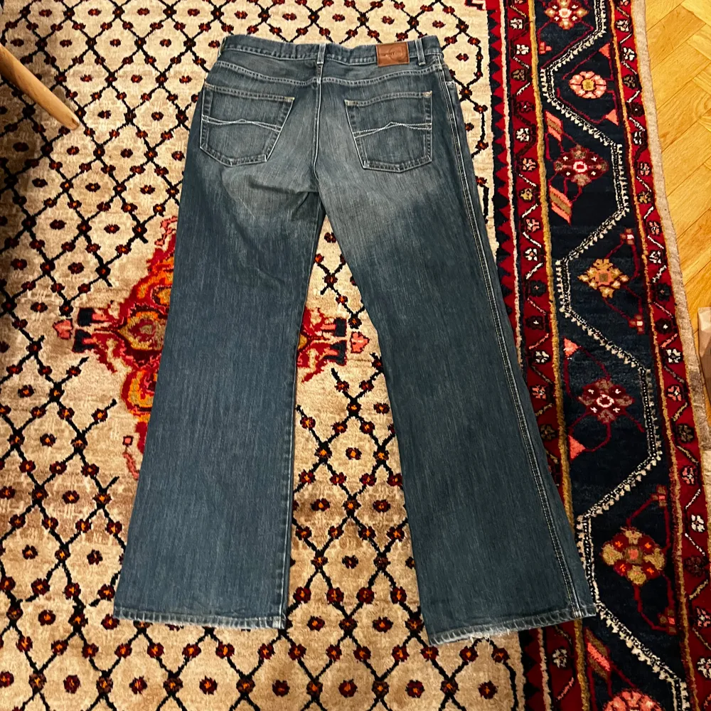 Säljer ett par snygga blå bootcut jeans i bra skick. De har en klassisk femficksdesign och en bekväm passform. Perfekta för både vardag och fest! 🕺. Jeans & Byxor.