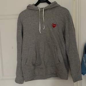 Säljer en grå hoodie  från CDG play i storlek M. Perfekt till alla tillfällen. Hoodien är i mycket bra skick då jag knappast använt den. Nypris: Ca 2500 Mitt pris 599 Skriv vid minsta lilla fundering!