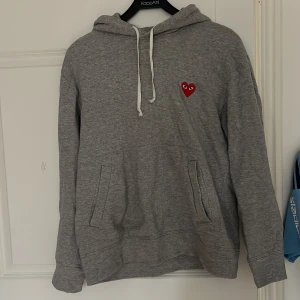 CDG play hoodie - Säljer en grå hoodie  från CDG play i storlek M. Perfekt till alla tillfällen. Hoodien är i mycket bra skick då jag knappast använt den. Nypris: Ca 2500 Mitt pris 599 Skriv vid minsta lilla fundering!