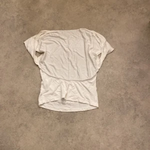 Vit topp från Shein - Säljer en vit topp från Shein i storlek S. Den är tillverkad av mjuk viskos och elastan, vilket gör den bekväm och stretchig. Perfekt för vardagsbruk eller att klä upp med accessoarer. Toppen har en enkel design med korta ärmar.