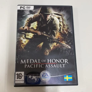 Medal of Honor: Pacific Assault PC-spel - Säljer ett PC-spel, Medal of Honor: Pacific Assault, från EA Games. Spelet är i en svart DVD-fodral med en dramatisk omslagsbild av en soldat i strid. Det är märkt för 16+ och har en svensk flagga på framsidan. Perfekt för dig som gillar actionfyllda krigsspel och vill uppleva intensiva strider i Stilla havet.
