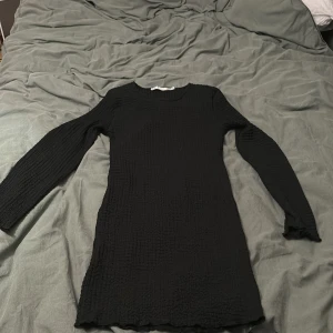 Svar klänning - Säljer en svart klänning i mycket bra skick. Den har en enkel och stilren design med långärmade ärmar, perfekt för höst och vinter. Klänningen är i en normal passform och passar både till vardags och festligare tillfällen. Använd en gång 