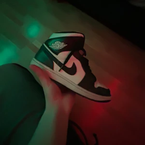 Nike Air Jordan 1 Mid - Säljer ett par Nike Air Jordan 1 Mid i mörkblå/navy och vit färg. Skorna är i hyfsat bra skick och kommer i originalkartong. Perfekta för både vardag och fest med sin ikoniska design och bekväma passform. Passa på att få tag i dessa klassiker! Pris ej hugget i sten!! Tveka inte att kontakta vid ev frågor.