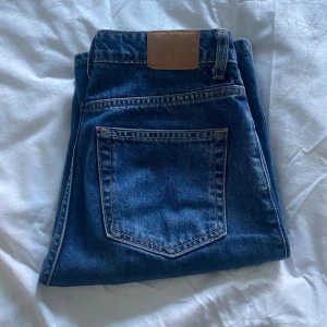 Weekday Jeans i mörkblå tvätt - Säljer ett par jeans från Weekday i mycket bra skick. Modellen heter Rowe och jeansen har en snygg straight passform och är i mycket bra skick. Jeansen är i slitstarkt Demin och inte särskild stretchiga. Säljer då de har blivit för små! STORLEK: 26/34
