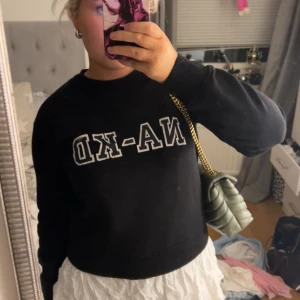 Svart tröja från NA-KD - Säljer en svart tröja från NA-KD i mycket bra skick. Den har en enkel design med vit text på framsidan. Perfekt för en casual look och passar bra till både jeans och kjol. Tröjan är bekväm och har långa ärmar.