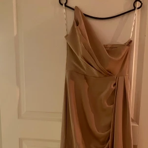 Klänning  - Storlek 36c champagne färgade elegant klänning från club l. Endast använd en gång. Super fin till festligheter!