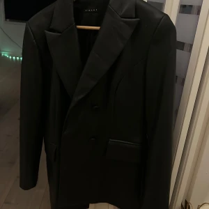 Skinnjacka  - Längre skinnjacka som sitter lite tajt i midjan, super snygg. En knapp saknas men syns inte alls mycket. Använt fåtal gånger!