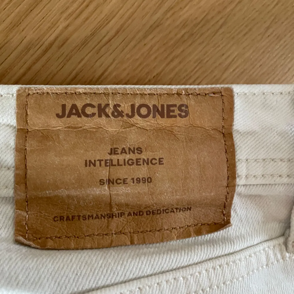 Säljer ett par vita jeans från Jack & Jones i storlek 28/32. De har en klassisk femficksdesign och knappar i gylfen. Perfekta för en stilren look året runt. Passar både till vardags och fest!. Jeans & Byxor.