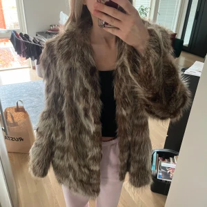 Brun pälsjacka - Säljer en supermysig brun pälsjacka i mycket bra skick. Den är perfekt för höst och vinter och har långa ärmar. Jackan är i en oversized passform och ger en lyxig känsla. Perfekt för att hålla sig varm och stilren under kyliga dagar! Strl XL tror jag men jag är strl S