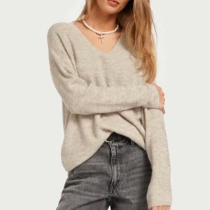 Beige V-ringad tröja från Vero Moda - Säljer en supermysig beige tröja från Vero Moda. Den har en snygg v-ringning och är perfekt för både vardag och lite finare tillfällen. Tröjan är i ett mjukt material och har långa ärmar. Perfekt att matcha med jeans eller kjol för en stilren look! Märke JJXX men samma som på bilden! Nypris 299