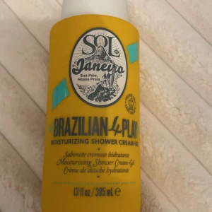 Sol de Janeiro Brazilian 4 Play Shower Cream-Gel - En återfuktande duschkräm-gel från Sol de Janeiro i en solig gul flaska. Den innehåller 395 ml och har en tropisk doft som ger en lyxig duschupplevelse. Perfekt för att hålla huden mjuk och len.