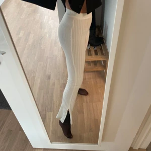 Vita ribbade byxor med slits - Säljer ett par högmidjade ribbade byxor med en snygg slits vid bensluten. Strl XXS men passar även XS🥰