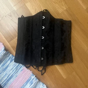 Korsett - Nästintill oanvänd korsett. Har max använt den 3 gånger. Det är en underbust och har en typ ish floral velvet mönster! 