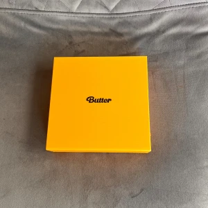 BTS - 'Butter' album - Säljer BTS albumet 'Butter'. Inuti finns en CD, fotobok, fotokort och andra samlarobjekt. Perfekt för fans av kpopmusik men framförallt BTS. Lådan är i bra skick och har en stilren design. 🎶💛